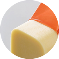 Casing being removed off of a piece of cheese